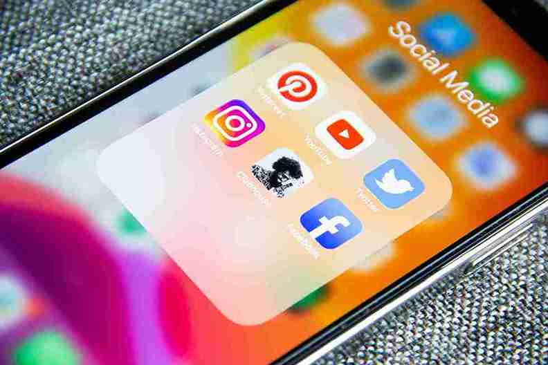 A close-up of a smartphone screen showing a folder named 'Social Media' which contains the app icons for Instagram, Pinterest, YouTube, Twitter, and Facebook.