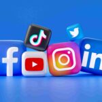 A collection of 3D social media logos, including Facebook, Instagram, YouTube, TikTok, LinkedIn, and Twitter, clustered together on a blue background